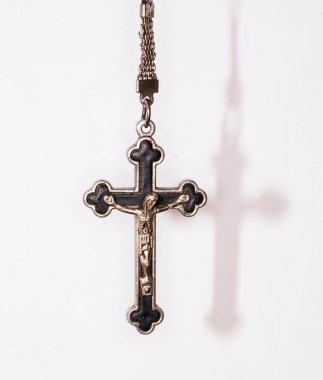 Karanlık bir arka planda metal haç. Din kavramı. Hristiyan sembolleri. Ortasında İsa figürü olan erkek haçı, gümüşten yapılmış, kordonla takılmış. Zincirle de takılabilir.