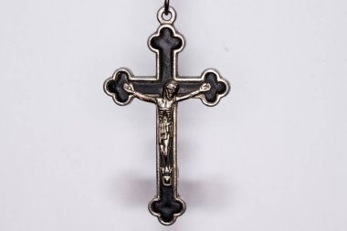 Karanlık bir arka planda metal haç. Din kavramı. Hristiyan sembolleri. Ortasında İsa figürü olan erkek haçı, gümüşten yapılmış, kordonla takılmış. Zincirle de takılabilir.