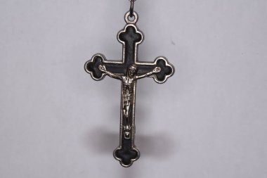 Karanlık bir arka planda metal haç. Din kavramı. Hristiyan sembolleri. Ortasında İsa figürü olan erkek haçı, gümüşten yapılmış, kordonla takılmış. Zincirle de takılabilir.