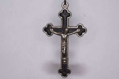 Karanlık bir arka planda metal haç. Din kavramı. Hristiyan sembolleri. Ortasında İsa figürü olan erkek haçı, gümüşten yapılmış, kordonla takılmış. Zincirle de takılabilir.