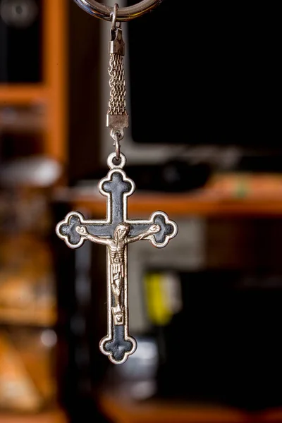 Metal cross on a dark background. Concept of religion. Christian symbols. Male crucifix with figure of Jesus Christ in the center, made of silver, worn with a cord. It can also be worn with a chain