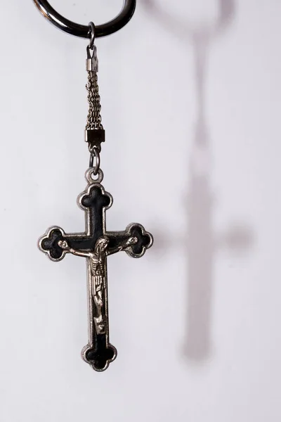 stock image Metal cross on a dark background. Concept of religion. Christian symbols. Male crucifix with figure of Jesus Christ in the center, made of silver, worn with a cord. It can also be worn with a chain