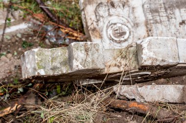 İnşaat alanında kırık mermer haçlar. Bir mezarlığın yıkılması. Mezarlıkta terk edilmiş bir mezar taşı, yakın plan fotoğraf.