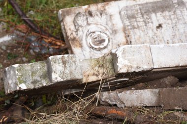 İnşaat alanında kırık mermer haçlar. Bir mezarlığın yıkılması. Mezarlıkta terk edilmiş bir mezar taşı, yakın plan fotoğraf.