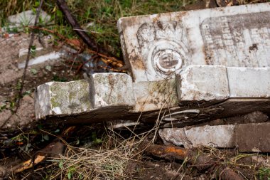 İnşaat alanında kırık mermer haçlar. Bir mezarlığın yıkılması. Mezarlıkta terk edilmiş bir mezar taşı, yakın plan fotoğraf.