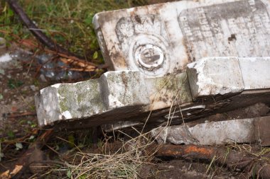 İnşaat alanında kırık mermer haçlar. Bir mezarlığın yıkılması. Mezarlıkta terk edilmiş bir mezar taşı, yakın plan fotoğraf.