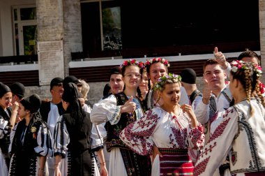 Gorj ilçesinden genç halk dansçıları geometrik ve çiçek desenli dikişli renkli geleneksel ulusal kostümler giyerler.