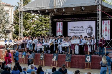 Gorj ilçesinden genç halk dansçıları geometrik ve çiçek desenli dikişli renkli geleneksel ulusal kostümler giyerler.