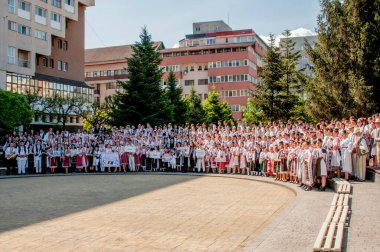 Gorj ilçesinden gelen halk müziği sanatçıları geometrik ve çiçek desenli parlak renkli geleneksel ulusal kostümler giyiyorlar..