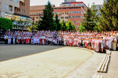 Gorj ilçesinden gelen halk müziği sanatçıları geometrik ve çiçek desenli parlak renkli geleneksel ulusal kostümler giyiyorlar..