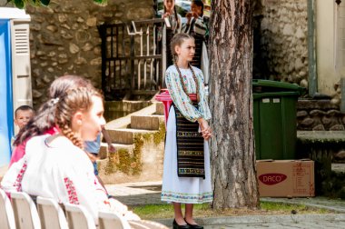 Gorj ilçesinden gelen halk müziği sanatçıları geometrik ve çiçek desenli parlak renkli geleneksel ulusal kostümler giyiyorlar..