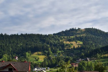 Arkasında bir ev olan dağların güzel bir görüntüsü.