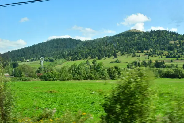 Yeşil alan ve arka planda küçük bir dağ köyü.