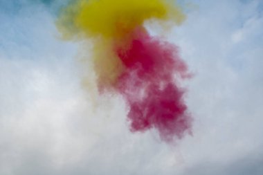 Mavi gökyüzünün arka planında renkli duman