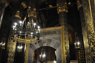 Kilise içi mumlar ve avizelerle dolu.