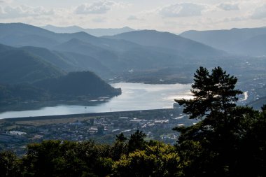 Güzel bir gölün panoramik görüntüsü ve arka planda dağlar.