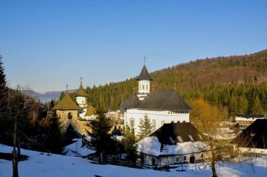 Arka planda dağlarda kilise olan güzel kış manzarası.