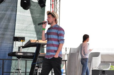 Şarkıcı sahnede şarkı söyler