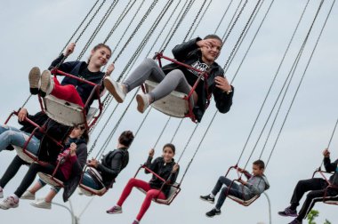 Bir grup mutlu arkadaş bulutlu bir günde lunaparkta eğleniyorlar..