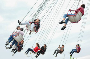 Paris 'teki lunaparkta salıncakta sallanan insanlar.