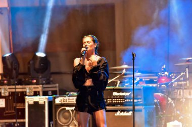 Şarkıcı konserde şarkı söylüyor.