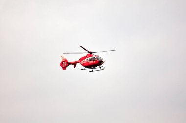 Kırmızı helikopter havada.