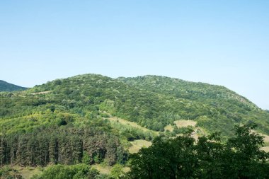 Dağları ve mavi gökyüzü olan güzel bir manzara.