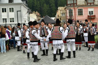 Romanya 'nın Vatra Dornei kenti, Romanya, 24 Haziran 2024 Genç veya yaşlı, Bucovina' lı kadın ve erkekler geleneksel Romen kostümleri veya geleneksel Romen gömlekleri giydiler.