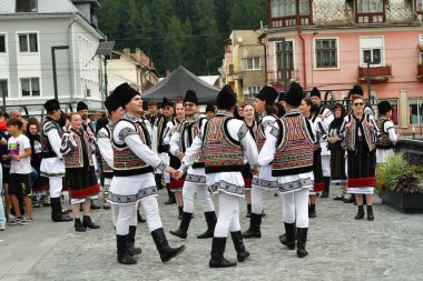 Romanya 'nın Vatra Dornei kenti, Romanya, 24 Haziran 2024 Genç veya yaşlı, Bucovina' lı kadın ve erkekler geleneksel Romen kostümleri veya geleneksel Romen gömlekleri giydiler.