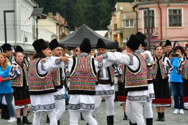 Romanya 'nın Vatra Dornei kenti, Romanya, 24 Haziran 2024 Genç veya yaşlı, Bucovina' lı kadın ve erkekler geleneksel Romen kostümleri veya geleneksel Romen gömlekleri giydiler.