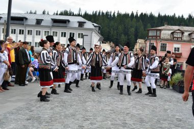 Vatra Dornei, Romanya, 24 Haziran 2024 Genç veya yaşlı, Bucovina 'lı kadın ve erkekler geleneksel Romen kostümleri veya geleneksel Romen gömleklerini Sanzien Günü' nde giydiler