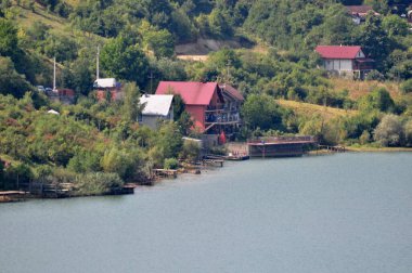 Göl kenarındaki ahşap evin manzarası.