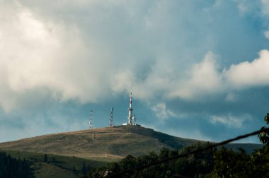 Tepede güzel gökyüzü olan yüksek bir kule.