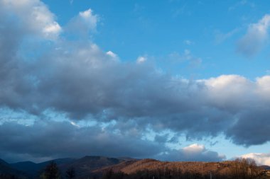 Mavi bulutlu gökyüzünün altındaki dağların güzel manzarası.