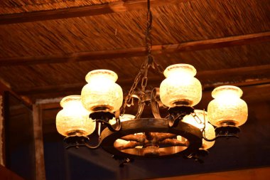 Karanlık odanın tavanında avize var.