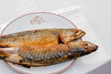 Tabakta balık, kızarmış patates ve sarımsak.