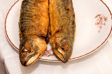 Beyaz arka planda limonlu ızgara balık.