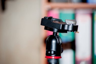 Arka planda tripodu olan bir kamera..