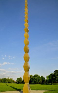 Büyük yuvarlak, sarı ve beyaz yuvarlak bir topun dikey görüntüsü açık mavi gökyüzünde