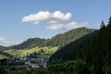Dağları ve mavi gökyüzü olan güzel bir manzara.