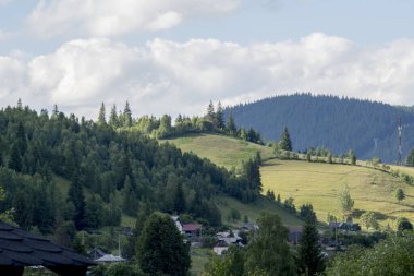 Yeşil ağaçlar, dağlar ve mavi gökyüzüyle güzel bir yaz manzarası
