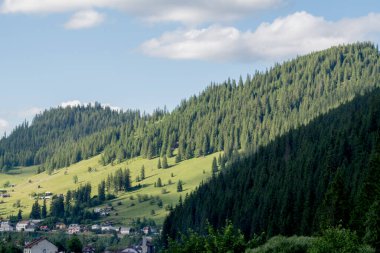 Bir dağ ve küçük bir evi olan güzel bir manzara.