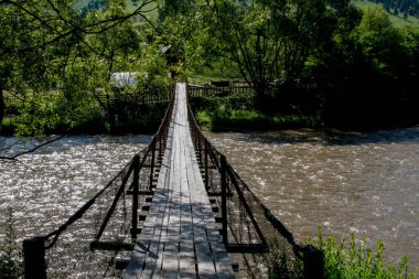 bir akarsu üzerinde ahşap köprü