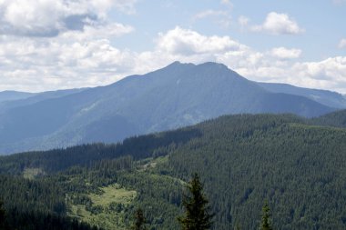 Karpatlar 'da yaz manzarası dağlarda, bulutlar, mavi gökyüzü ve dağdan güzel bir manzara.
