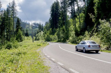 Dağlarda yolda giden bir araba. seyahat ve turizm