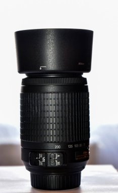 Yakın plan - Ahşap bir masada siyah lensli profesyonel bir kamera.