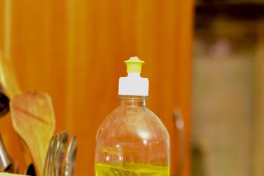 Bir şişe zeytinyağı ve zeytinyağı fotokopi alanı olan ahşap masa üzerinde.