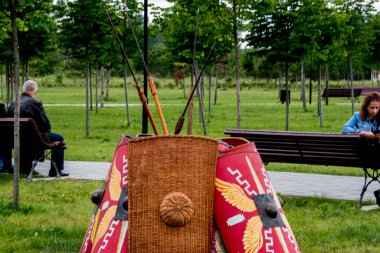 Kırmızı gömlekli bir adam parkta bankta oturuyor..