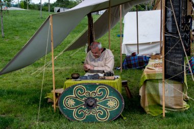 Siyah elbiseli yaşlı adam kılıçlı.