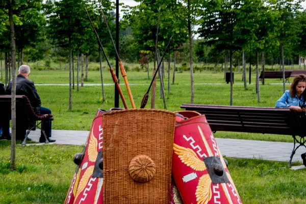 Kırmızı gömlekli bir adam parkta bankta oturuyor..